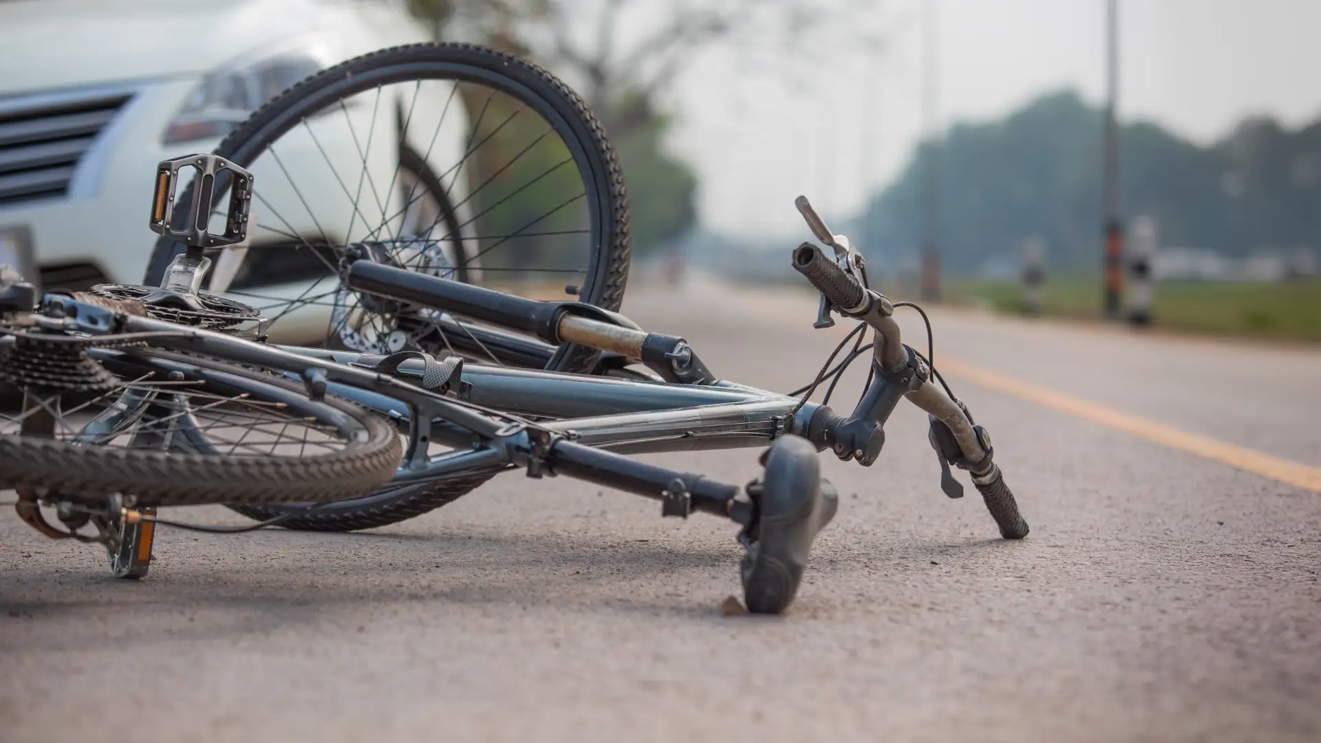 Damaged bicycle lying on the road after an apparent accident.