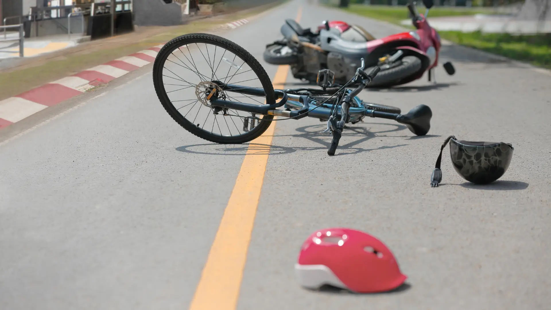 A fallen bicycle and helmet on the side of the road, indicating a potential cycling accident.