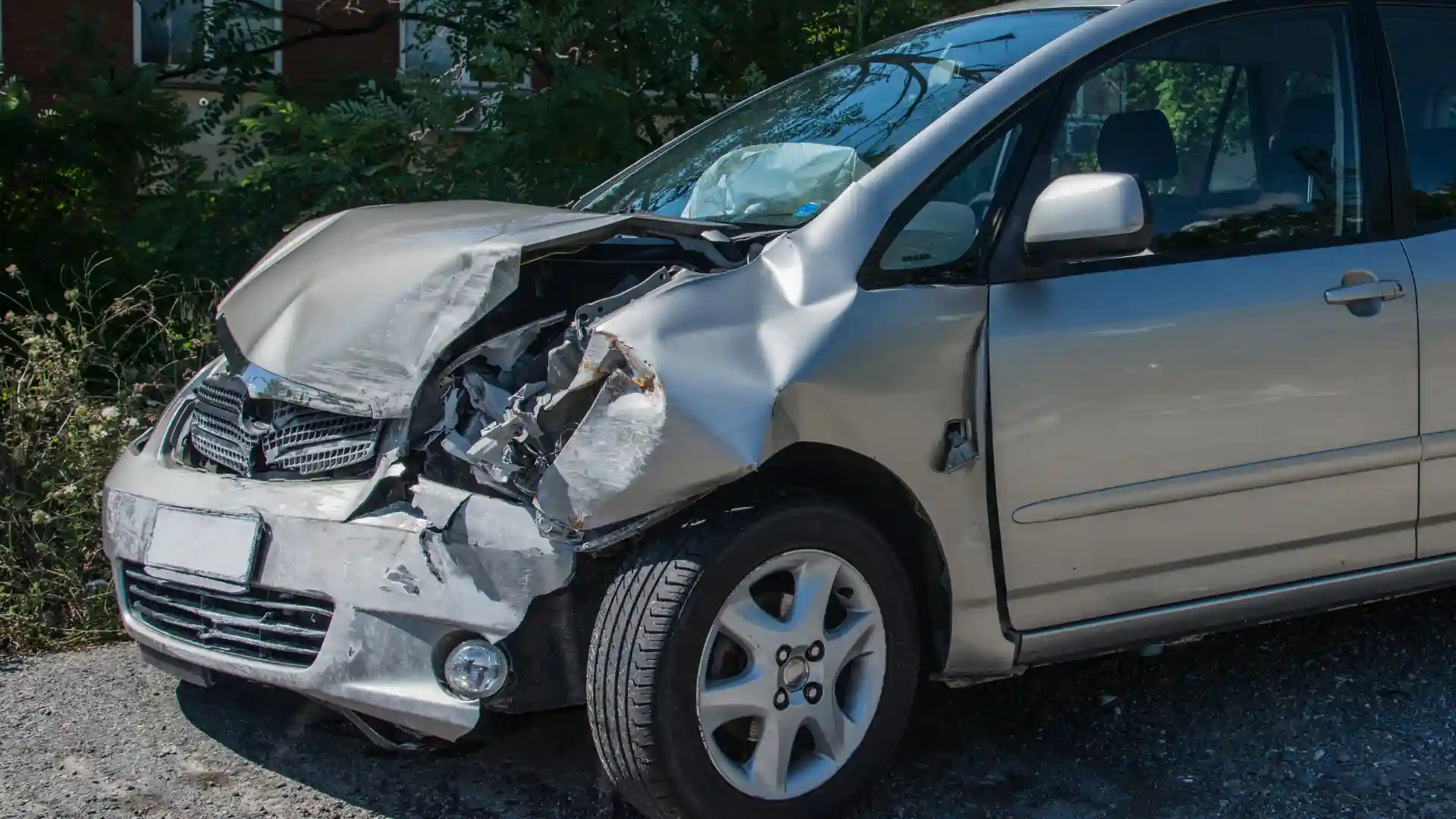 A damaged silver car with a crushed front bumper, likely from a car accident.