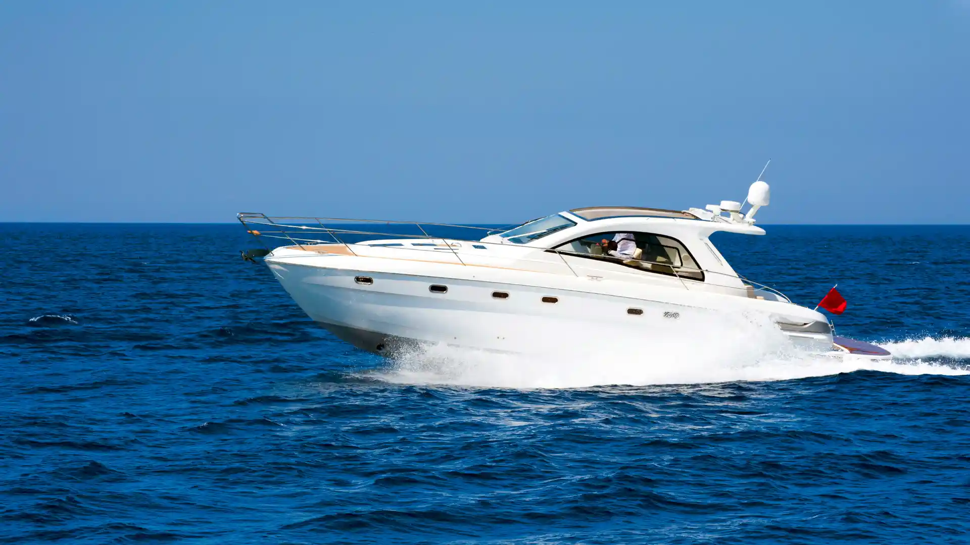 White motorboat cruising on the open sea.